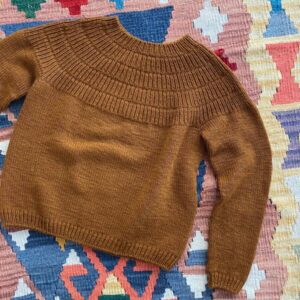 PetiteKnit Anker's Sweater – My Size ist aus Sunday von Sandnes Garn in der Farbe 2345 gestrickt. Die Farbe ist nicht mehr erhältlich, die Farbe 2543 Brown Sugar kommt ihr in unserem Sortiment am nächsten.