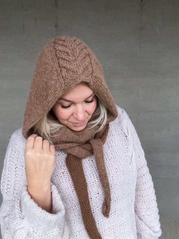 The Crown Hood Scarf by PoolaKnits is knitted in Ruukin kehräämö Alpakka in colorway Light Camel. The closest match in our selection is Sandnes Garn Alpakka Ull in color 2650 Grey Beige Heather.