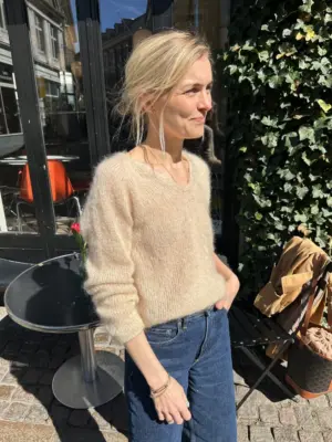 The beige Cumulus Blouse is knitted in Tynn Silk Mohair by Sandnes Garn in the color Almond [2511].