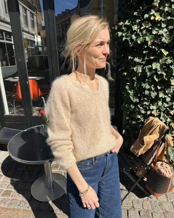 The beige Cumulus Blouse is knitted in Tynn Silk Mohair by Sandnes Garn in the color Almond [2511].