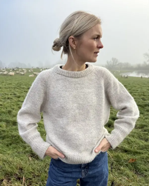 The grey Monday Sweater is knitted in Pelsuld 8/2 by Hjelholt Uldspinderi in the color Sand [04] held together with Soft Silk Mohair by Knitting for Olive in the color Marcipan.