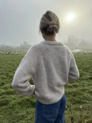 The grey Monday Sweater is knitted in Pelsuld 8/2 by Hjelholt Uldspinderi in the color Sand [04] held together with Soft Silk Mohair by Knitting for Olive in the color Marcipan.