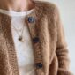 The brown Novice Cardigan - Chunky Edition is knitted in Kos by Sandnes Garn in the color Brunt sukker [2543] held together with Tynn Silk Mohair by Sandnes Garn in the color Brunt sukker [2543]. The colors are discontinued.