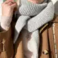 The light grey Sophie Shawl is knitted in Cashmere Classic by Lang Yarns in the color 0003 in size S.