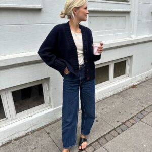 The dark blue Eva Cardigan is knitted in Peer Gynt by Sandnes Garn in the color Night sky [5591].