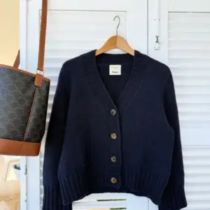 The dark blue Eva Cardigan is knitted in Peer Gynt by Sandnes Garn in the color Night sky [5591].