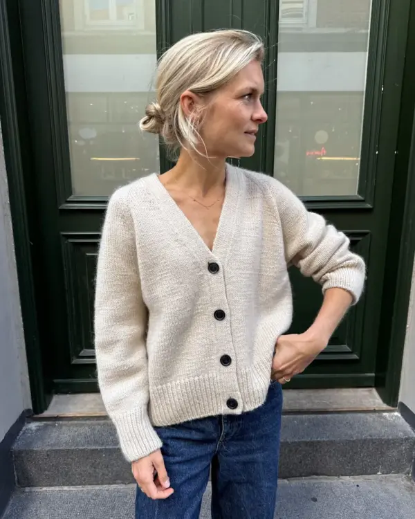 The white Champagne Cardigan is knitted in Double Sunday by Sandnes Garn in the color Almond [2511] held together with Tynn Silk Mohair by Sandnes Garn in the color Kitt [1015].