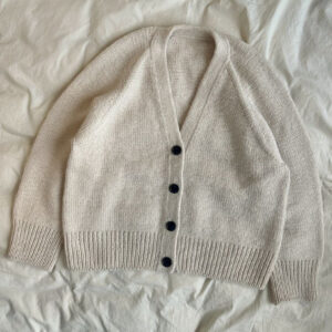The white Champagne Cardigan is knitted in Double Sunday by Sandnes Garn in the color Almond [2511] held together with Tynn Silk Mohair by Sandnes Garn in the color Kitt [1015].