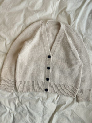 The white Champagne Cardigan is knitted in Double Sunday by Sandnes Garn in the color Almond [2511] held together with Tynn Silk Mohair by Sandnes Garn in the color Kitt [1015].