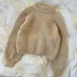 De beige Louisiana-trui is gebreid van Bouclé van Isager in kleur 6S.