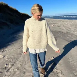 The white Louvre Sweater is knitted in Peer Gynt by Sandnes Garn in the color Natural Tweed [2523].