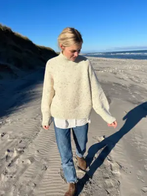 The white Louvre Sweater is knitted in Peer Gynt by Sandnes Garn in the color Natural Tweed [2523].