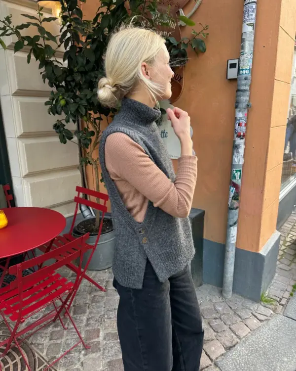 The grey Lulu Slipover is knitted in Peer Gynt by Sandnes Garn in the color Charcoal melange [1065].