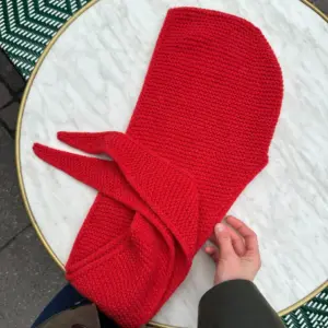The red Sophie Hood is knitted in Eco Cashmere Vintage by Gepard in the color Blodappelsin [325].