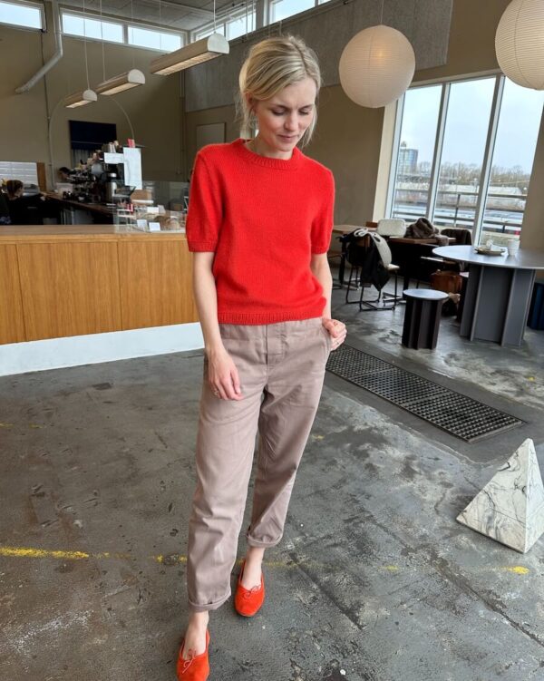 The red Poppy Tee is knitted in Cashmere Classic by Cardiff in the color Hermes [517].