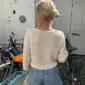 The white Sevilla Blouse is knitted in Palet by Isager in color White held together with Trio 1 by Isager in the color Linen.