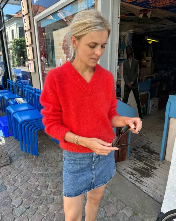 The red Stockholm Sweater V-Neck is knitted in Tynn Silk Mohair by Sandnes Garn in the color 4008 Poppy. The color is discontinued and the closest match in our selection is the color 4018 Scarlet Red.