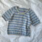 Das weiß-blaue Amélie Tee aus dem Garn „Sunday“ von Sandnes Garn in den Farben „Almond“ [2511] und „Baby blue eyes“ [6043] gestrickt.