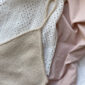 Das weiße „Cumulus Top“ wurde aus „Pure Silk“ von Knitting for Olive in der Farbe „Wheat“ gestrickt.