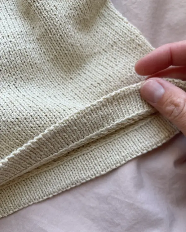 The white Cumulus Top is knitted in Pure Silk by Knitting for Olive in the color Wheat. Das weiße „Cumulus Top“ wurde aus „Pure Silk“ von Knitting for Olive in der Farbe „Wheat“ gestrickt.
